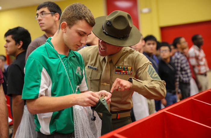 Gunnery Sgt. Jason J. Gutierrez, drill instructor, Receiving Company, Support Battalion, instructs a new recruit to move faster during receiving at Marine Corps Recruit Depot San Diego, Dec. 7. Recruits are required to follow all instructions from drill instructors throughout the course of training. In the week following receiving, they will conduct an initial strength test, undergo medical screenings and immunizations and learn the basic rules of recruit training. Today, all males recruited from west of the Mississippi are trained at MCRD San Diego. The depot is responsible for training more than 16,000 recruits annually. Echo Company is scheduled to graduate March 4.