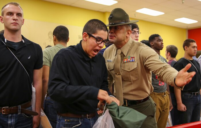 Staff Sgt. Joshua M. Cardona, drill instructor, Receiving Company, Support Battalion, instructs a recruit to respond louder during receiving at Marine Corps Recruit Depot San Diego, Dec. 7. In the week following receiving, they will conduct an initial strength test, undergo medical screenings and immunizations and learn the basic rules of recruit training. Today, all males from west of the Mississippi are trained at MCRD San Diego. The depot is responsible for training more than 16,000 recruits annually. Echo Company is scheduled to graduate from recruit training on March 4.