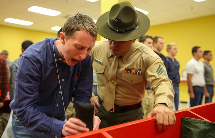 Sergeant Edwin A. Gonzales, drill instructor, Receiving Company, Support Battalion, instructs a new recruit to move faster during receiving at Marine Corps Recruit Depot San Diego, Dec. 7. Recruits are required to follow all instructions from drill instructors throughout the course of training. In the week following receiving, they will conduct an initial strength test, undergo medical screenings and immunizations and learn the basic rules of recruit training. Today, all males recruited from west of the Mississippi are trained at MCRD San Diego. The depot is responsible for training more than 16,000 recruits annually. Echo Company is scheduled to graduate March 4.
