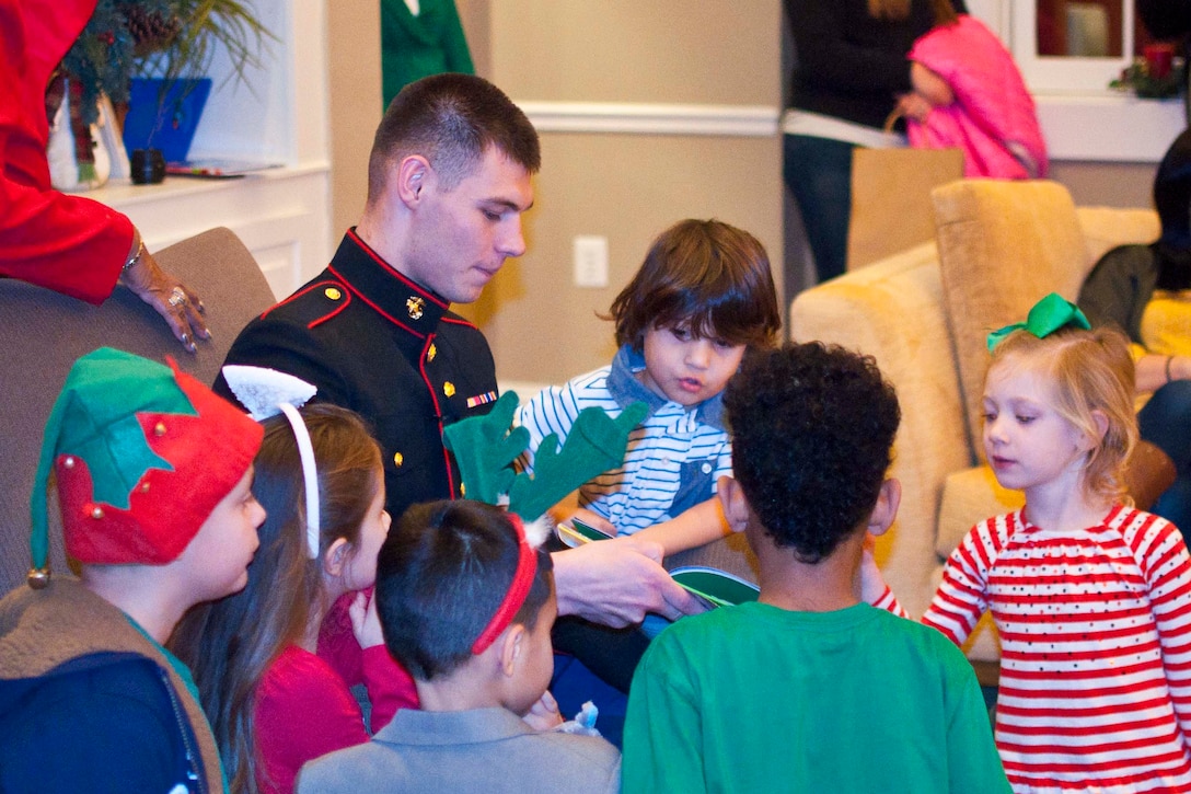 Lance Cpl. Blake Smith, Manpower Reserve Affairs Promotions Branch board clerk, reads a holiday story to children.