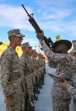 Staff Sgt. Brandon J. Curry, drill instructor, Golf Company, 2nd Recruit Training Battalion, inspects a recruit’s M16-A4 Service Rifle during a series commander inspection at Marine Corps Recruit Depot San Diego, Dec. 7. Drill instructors search for carbon that builds up on the recruits’ rifles over time. Recruits are given a significant amount of time to clean their rifles every day, if they decide to. Today, all males recruited west of the Mississippi are trained at MCRD San Diego. The depot is responsible for training more than 16,000 recruits annually. Golf Company is scheduled to graduate Jan. 8.