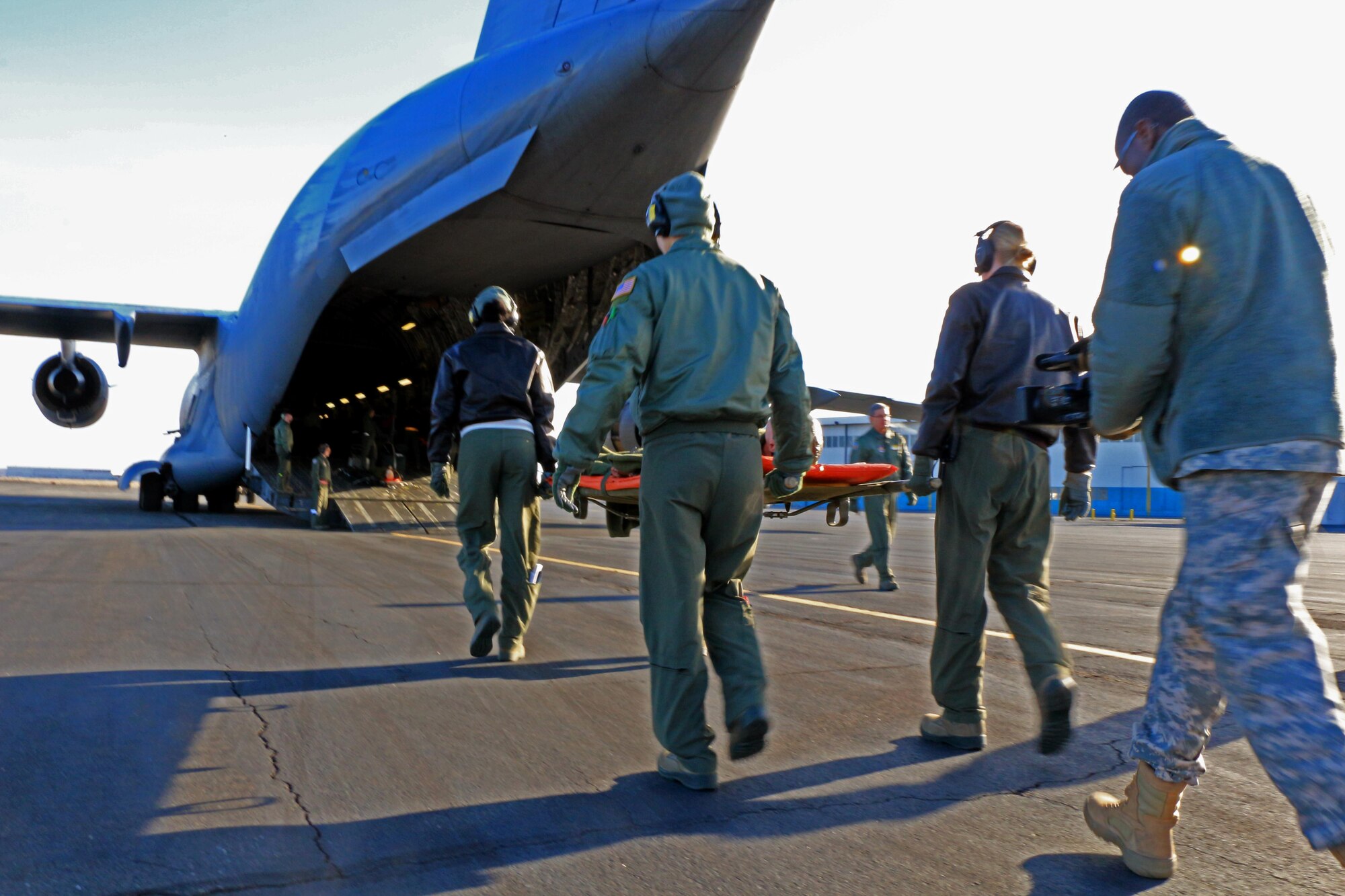 A 446th Aeromedical Evacuation Squadron team carries a patient onto a C-17 Globemaster III as part of training when the flight from McChord stopped in Moses Lake, Wash. Dec. 8. The 446th AES began a new training program with the 446th Aeromedical Staging Squadron over the Nov. 2013 UTA.