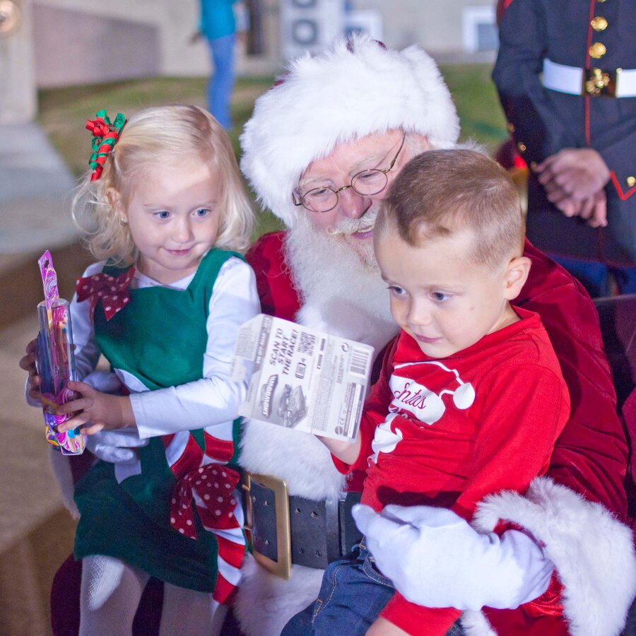 Three-year-old twins of Maj. Matthew Hill, Marine Corps University command and staff student and Katrin Hill meet Santa at the Fifth Annual Base Christmas Tree Lighting Ceremony at Lejeune Hall, Dec. 6. Children also took time to play in a bouncing house, climb into antique cars, create Christmas tree ornaments and dance to festive holiday music.