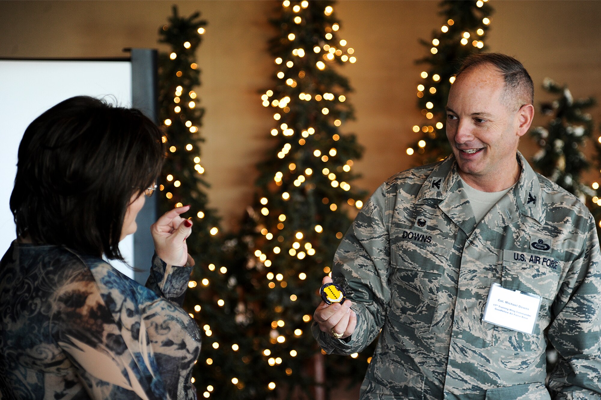 U.S. Air Force Col. Michael L. Downs, 17th Training Wing Commander, coins Dianna Spieker, Tom Green County Treasurer, at the San Angelo Country Club in San Angelo, Texas, Dec. 9, 2015. Downs presented Spieker with the challenge coin for coordinating the partnerships between Goodfellow Air Force Base and the city of San Angelo. (U.S. Air Force photo by Airman 1st Class Devin Boyer/Released)