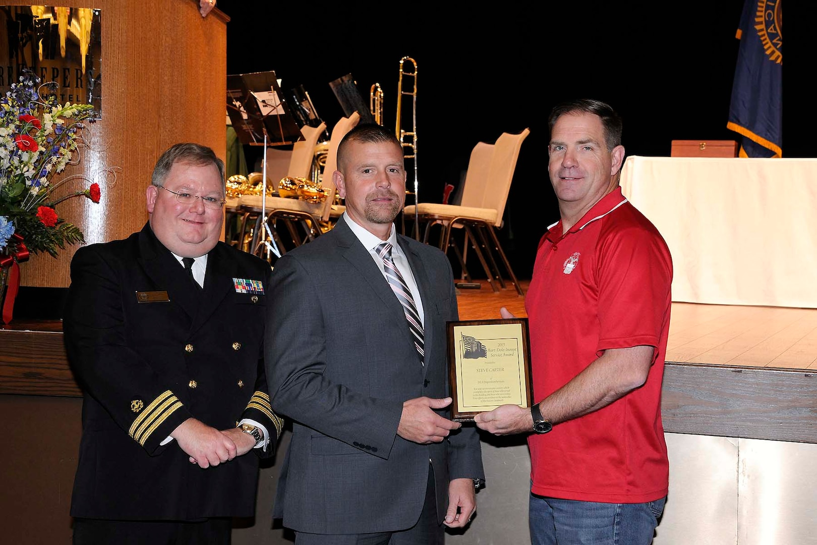 Steve Carter (center) receives the Hart-Dole-Inouye Federal Center Service Award from DLA Disposition Services Director Mike Cannon (right) and Retired Navy Cmdr. T.R. Shaw for demonstrating the “spirit of service” synonymous with the center and its namesakes.