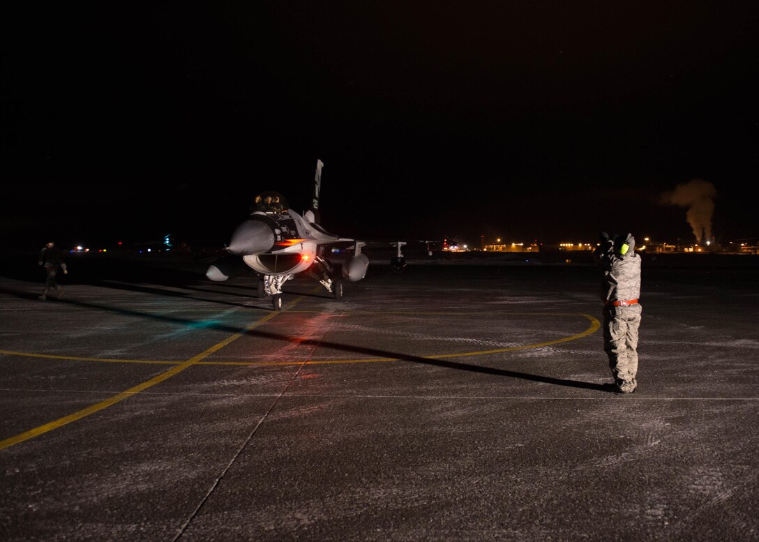 An Airman from the 354th Aircraft Maintenance Squadron, performs the last pre-flight checks on an F-16 Fighting Falcon fighter aircraft Dec. 7, 2015, at Eielson Air Force Base, Alaska. More than 30 maintenance Airmen worked an early shift to help launch several jets to Tyndall Air Force Base, Florida, for CHECKERED FLAG 16-1, a large-force exercise that simulates a large number of aircraft in a deployed environment to cross-check weapons systems. (U.S. Air Force photo by Staff Sgt. Shawn Nickel/Released)