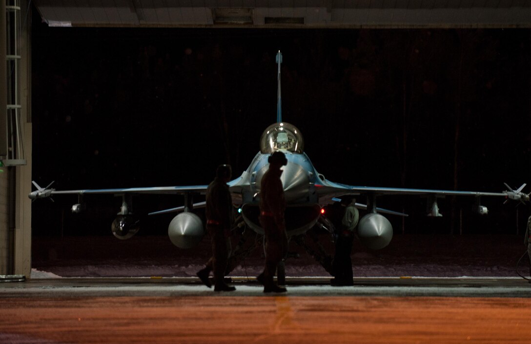 Crew chiefs with the 354th Aircraft Maintenance Squadron perform the last pre-flight checks on an F-16 Fighting Falcon fighter aircraft Dec. 7, 2015, at Eielson Air Force Base, Alaska. More than 30 maintenance Airmen worked an early shift to help launch several jets to Tyndall Air Force Base, Florida, for CHECKERED FLAG 16-1, a large-force exercise that simulates a large number of aircraft in a deployed environment to cross-check weapons systems. (U.S. Air Force photo by Master Sgt. Joseph Swafford/Released)