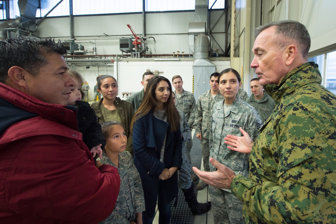 U.S. Marine Gen. Joseph F. Dunford Jr., chairman of the Joint Chiefs of Staff, talks with Air Force Staff Sgt. Nancy Kasberg and her family after she reenlisted at Ramstein Air Base, Germany, Dec. 9, 2015. Dunford traveled with entertainers from the 2015 USO Holiday Tour to visit deployed service members. DoD photo by D. Myles Cullen