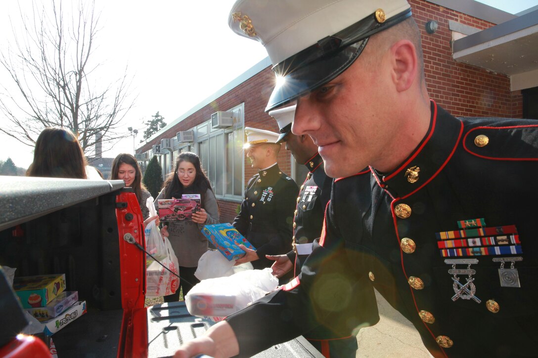 Franklin Square, NY.--  Staff Sgt. Nathan Uttech, a recruiter with Recruiting Station New York, helps students from H. Frank Carey High School load toys into a truck, Dec. 10. The toys are donations from the seniors of H. Frank Carey High School to kids through the United States Marine Corps Reserve “Toys for Tots” program. 