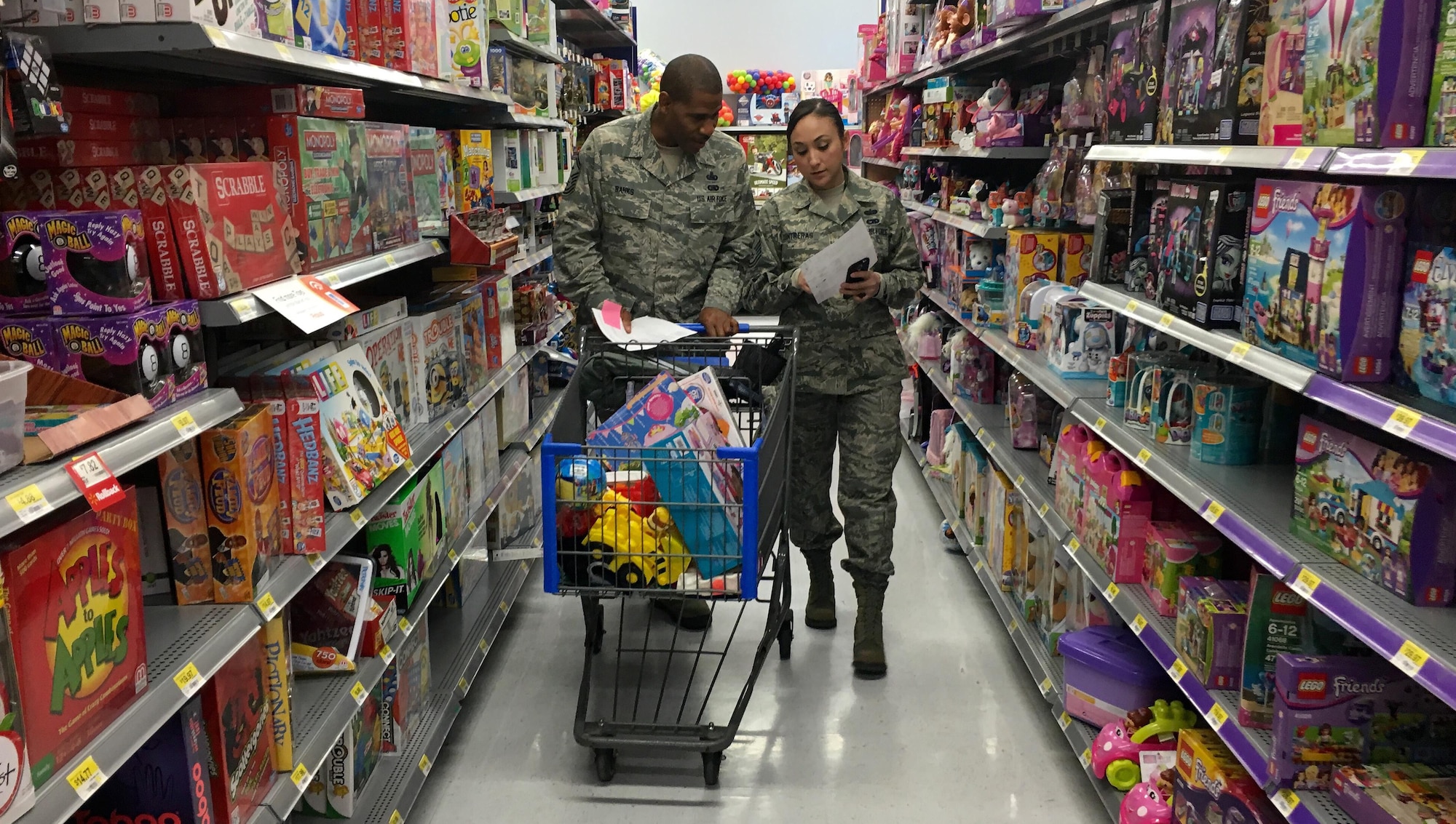 Senior Master Sgt. Martez Banks, 419th Aircraft Maintenance Squadron first sergeant, and Master Sgt. Ruby Contreras, 419th Civil Engineer Squadron first sergeant, search a toy aisle at a Walmart in Salt Lake City for Christmas wish-list items. A group of reservists from the 419th Fighter Wing volunteered to shop for families in need this holiday season. (U.S. Air Force photo/Bryan Magaña) 