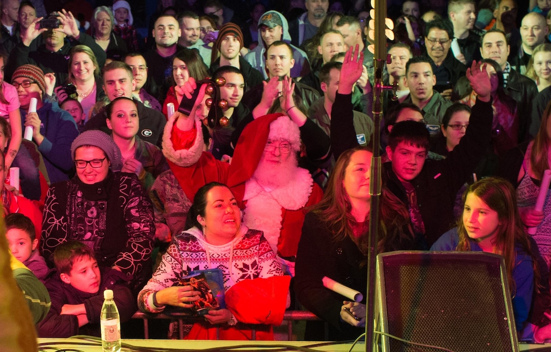 Santa Claus rings Christmas bells from the audience of a USO show at Ramstein Air Base, Germany, Dec. 9, 2015. Entertainers with the 2015 USO Holiday Tour traveled to various locations to visit service members deployed overseas. DoD photo by D. Myles Cullen