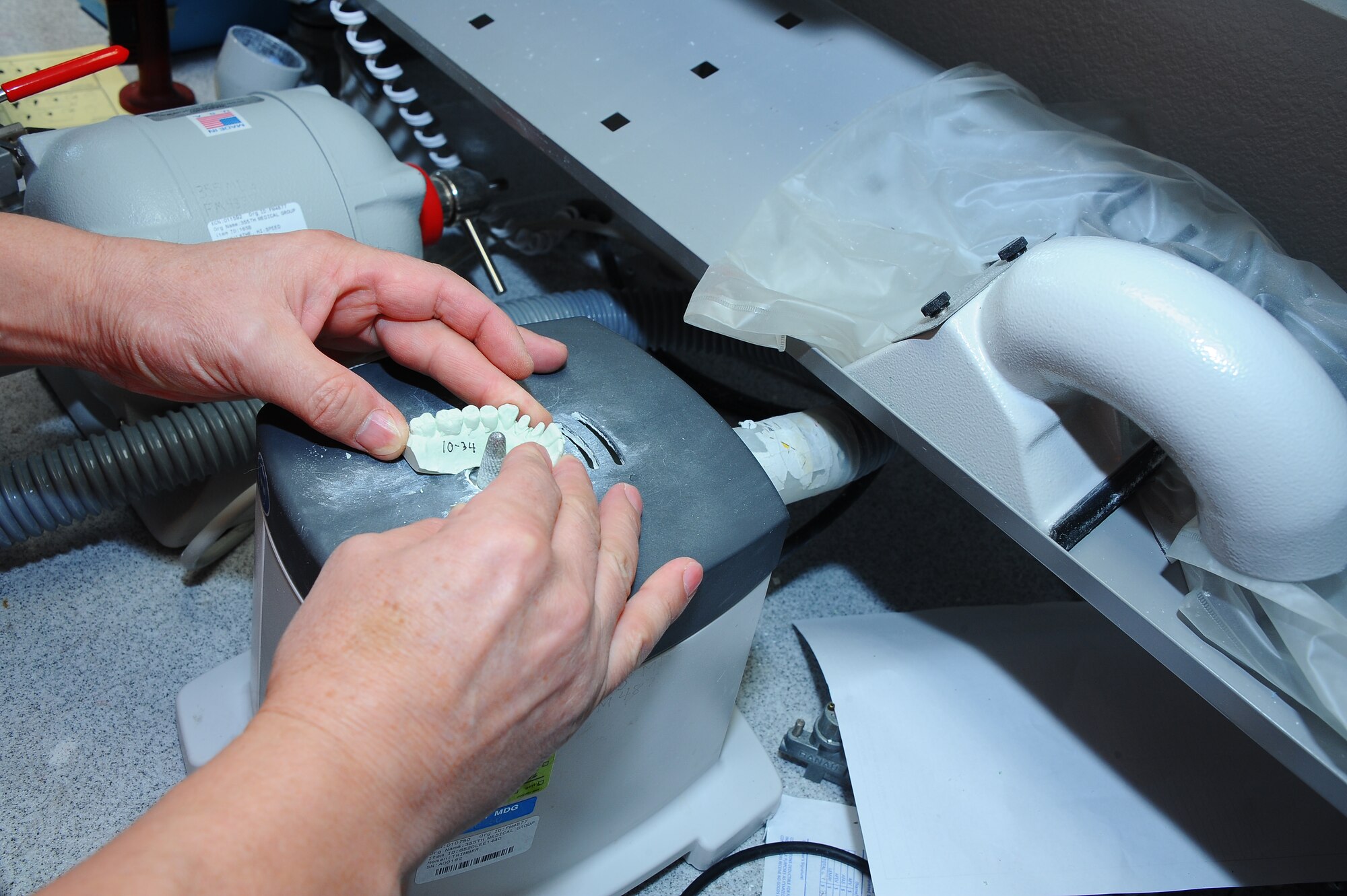Ismet Osmani, 355th Dental Squadron laboratory technician, trims excess material from dental impression cast at Davis-Monthan Air Force, Ariz., Nov. 3, 2015. The technicians fabricate and restore fixed and removable items for dental requests. (U.S. Air Force photo by Airman 1st Class Mya M. Crosby/Released)