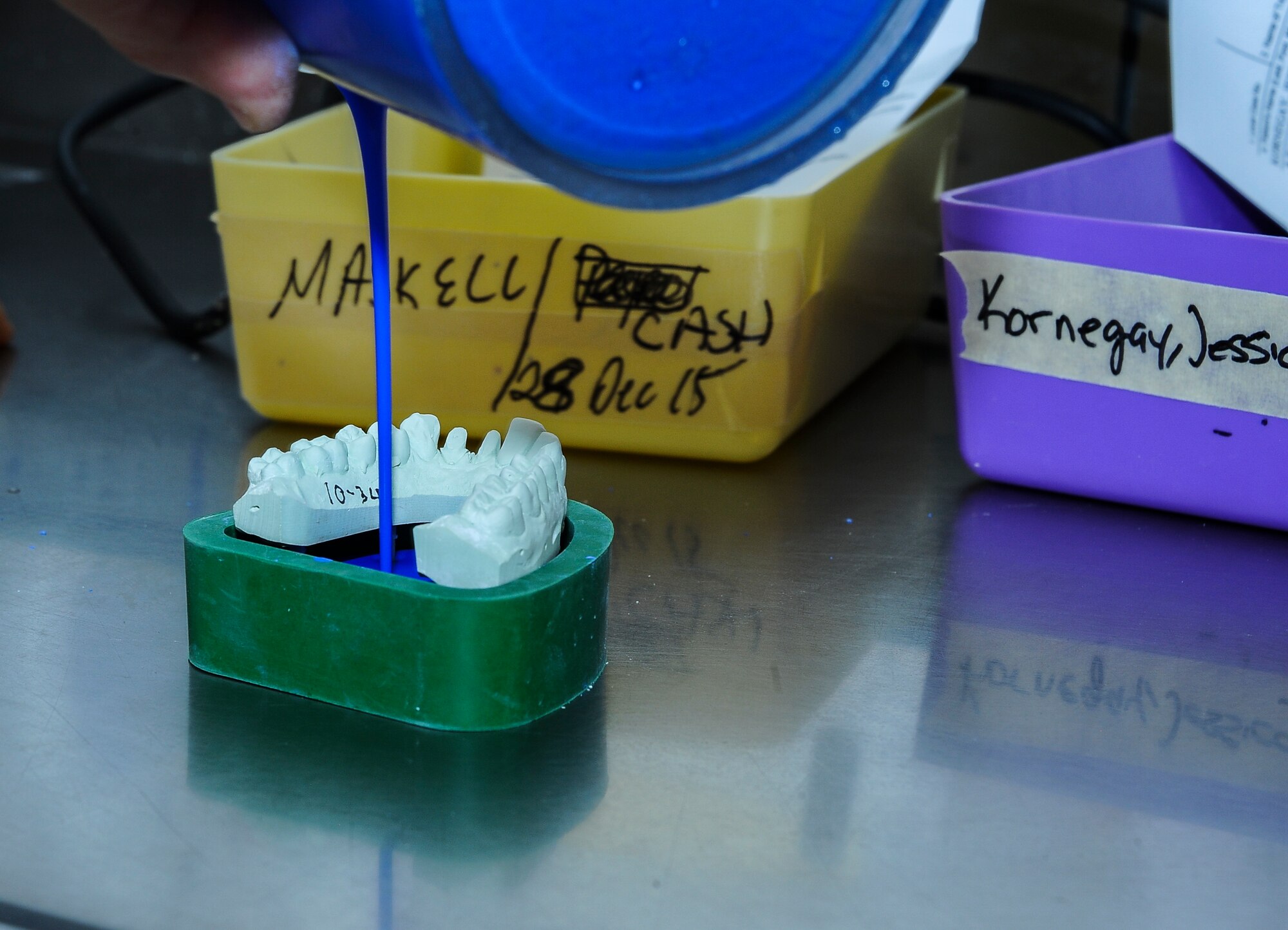 A dental laboratory technician assigned to the 355th Dental Squadron, pours flow stone under a dental impression cast in the 355th Dental Squadron laboratory at Davis-Monthan Air Force Base, Ariz., Nov. 3, 2015. A flow stone is used to hold a dental stone impression in place. (U.S. Air Force photo by Airman 1st Class Mya M. Crosby/Released) 
