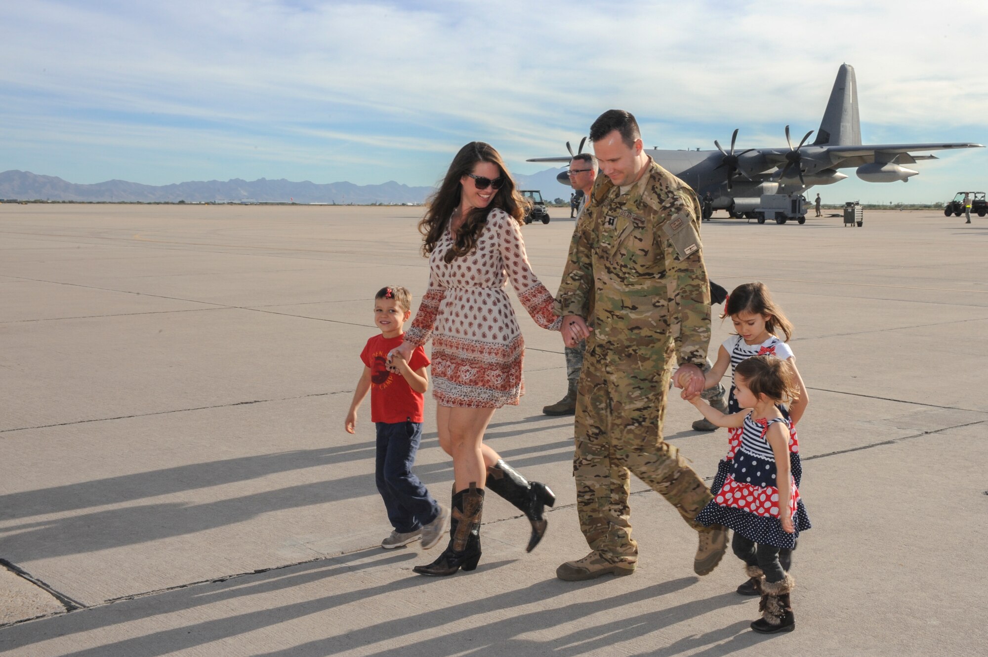 U.S. Air Force Capt. David Thomson, 79th Rescue Squadron combat systems officer, walks off the flightline with his wife, Kayla, and their three children at Davis-Monthan Air Force Base, Ariz., Dec. 10, 2015.  Members of the 79th RQS and 923rd Aircraft Maintenance Squadron returned from a 3-month deployment to Southwest Asia in support of Operation Inherent Resolve. (U.S. Air Force photo by Senior Airman Chris Massey/Released)