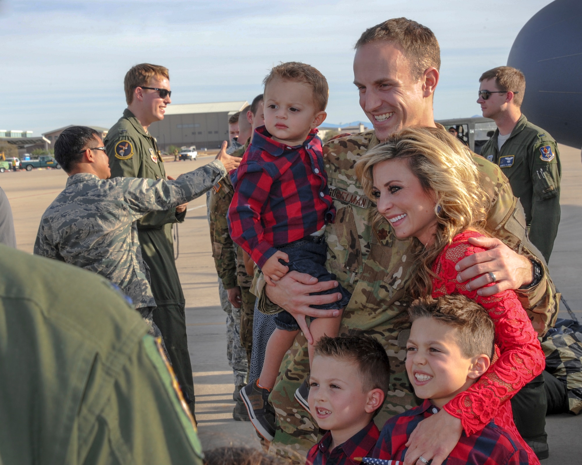 U.S. Air Force Maj. William Gugelman, 79th Rescue Squadron HC-130J Combat King II pilot, poses for a photo with his wife, Stephanie, and their three sons on the flightline at Davis-Monthan Air Force Base, Ariz., Dec. 10, 2015.  Gugelman rejoined his family after a 3-month deployment to Southwest Asia in support of Operation Inherent Resolve. (U.S. Air Force photo by Senior Airman Chris Massey/Released)