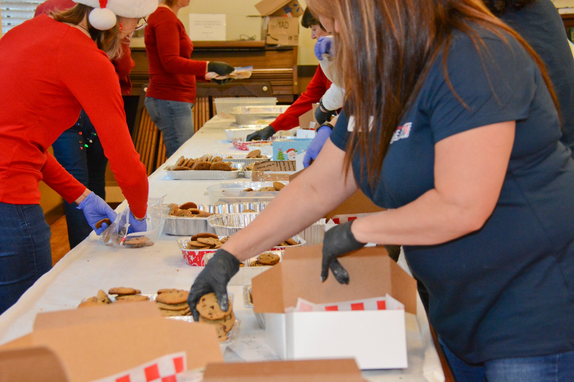 Volunteers helped box homemade cookies Dec. 9 at Travis Air Force Base, California during Operation Cookie Drop. The event's main goal is to box and deliver cookies to more than 800 Airmen living in the dorms. (U.S. Air Force photos by Airman 1st Class Amber Carter)