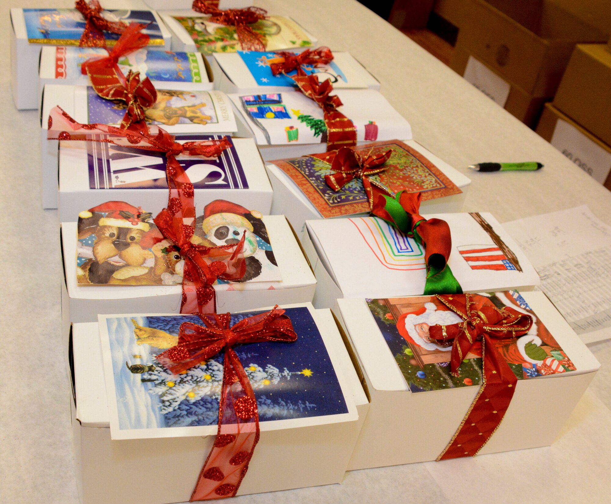 Boxes of cookies with a holiday card were wrapped with love and a bow by volunteers Dec. 9 during Operation Cookie Drop at Travis Air Force Base, California. (U.S. Air Force photos by Airman 1st Class Amber Carter)