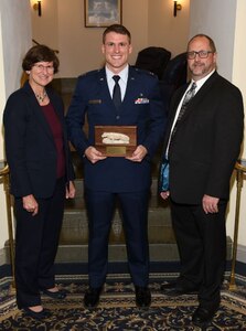 Capt David Lutz, 628th Air Base Wing executive officer, received the Emerging Professional’s Graduate Degree Award from Dr. Ann C. Crouter, College of Health and Human Development dean (left) and Jeffrey Sarabok, CHHD Alumni Society Board of Directors Officers president, during the CHHD Alumni Society Awards Dinner at Pennsylvania State University on Nov. 6, 2015. Lutz’s former professor and mentor, Joe Dionisio and his wife, Lois, were in attendance to congratulate Lutz on his award. (Courtesy photo)