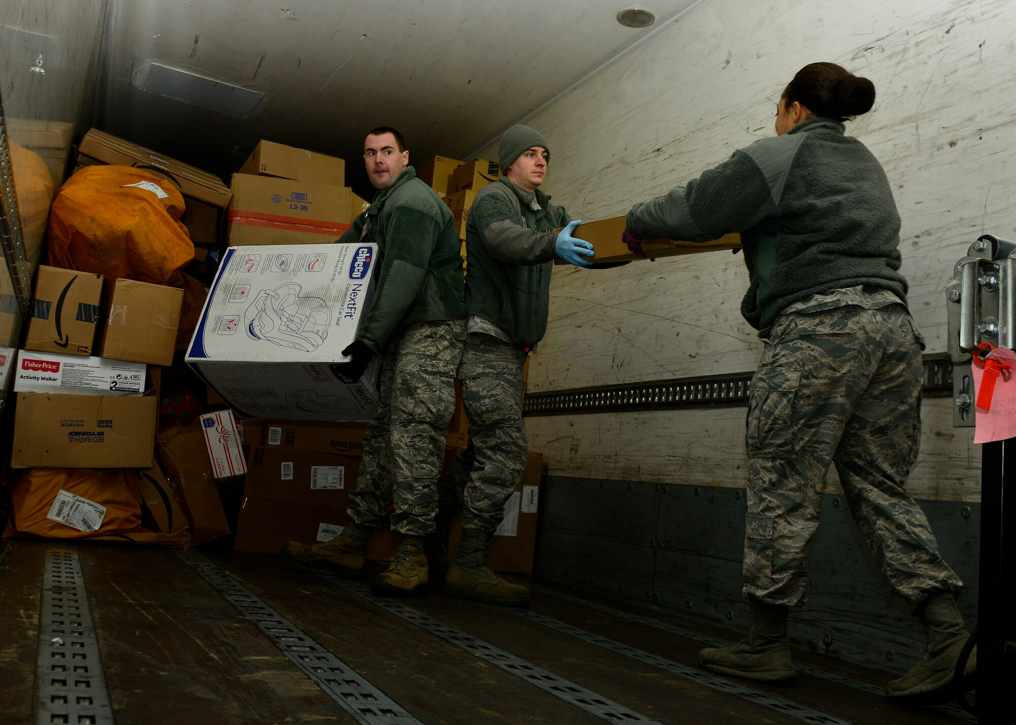 U.S. Air Force Airmen unload a mail delivery truck, Dec. 9, 2015, at Aviano Air Base, Italy. The post office is always looking for volunteers to help postal clerks unload trucks, sort mail, pitch letters into mailboxes and assist customers at the service window. (U.S. Air Force photo by Airmen 1st Class Cary Smith/Released)