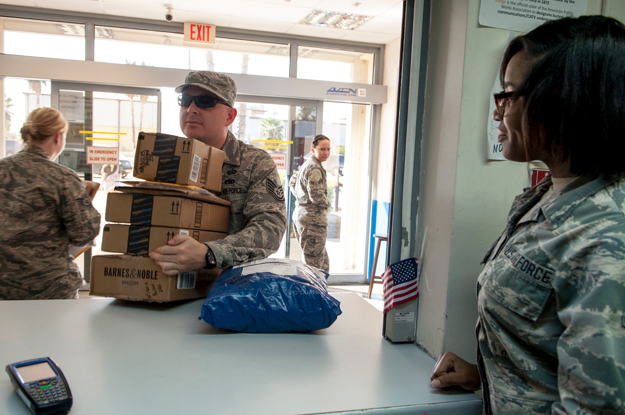 Tech.  Sgt. Nathen Bullard, 39th Logistics Readiness Squadron unit training manager, collects packages from Airman Aedilynne Paln, 39th Communications Squadron mail clerk, Nov. 17, 2015, at Incirlik Air Base, Turkey. Ensuring postal communication lines stay open is one of the many communication capabilities Airman from the 39th CS are tasked with. (U.S. Air Force photo by Staff Sgt. Jack Sanders/Released)