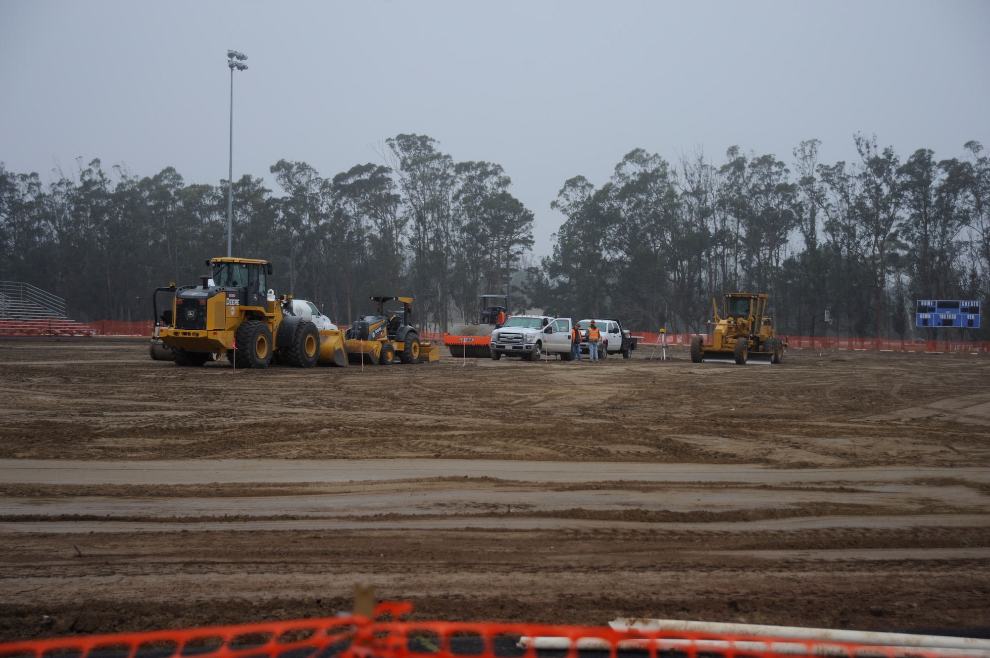 Construction members work on the athletic field at the base track, Dec. 10, 2015, Vandenberg Air Force Base, Calif. A project designed to remove the natural turf on the athletic field at the base track and replace it with artificial turf recently began construction Nov. 30. (U.S. Air Force photo by Airman 1st Class Robert J. Volio/Released)