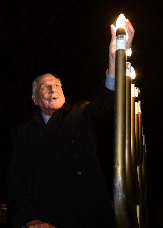 Rabbi Abraham Morhaim lights the menorah as part of a Hanukkah Candle Lighting ceremony outside the base chapel, Dec. 9. The Menorah lighting commemorates the eight-day celebration of Hanukkah, Dec. 6 through 14, also known as the festival of lights. During each night of the festival, an additional candle is lit. (U.S. Air Force photo by Jerry Saslav)