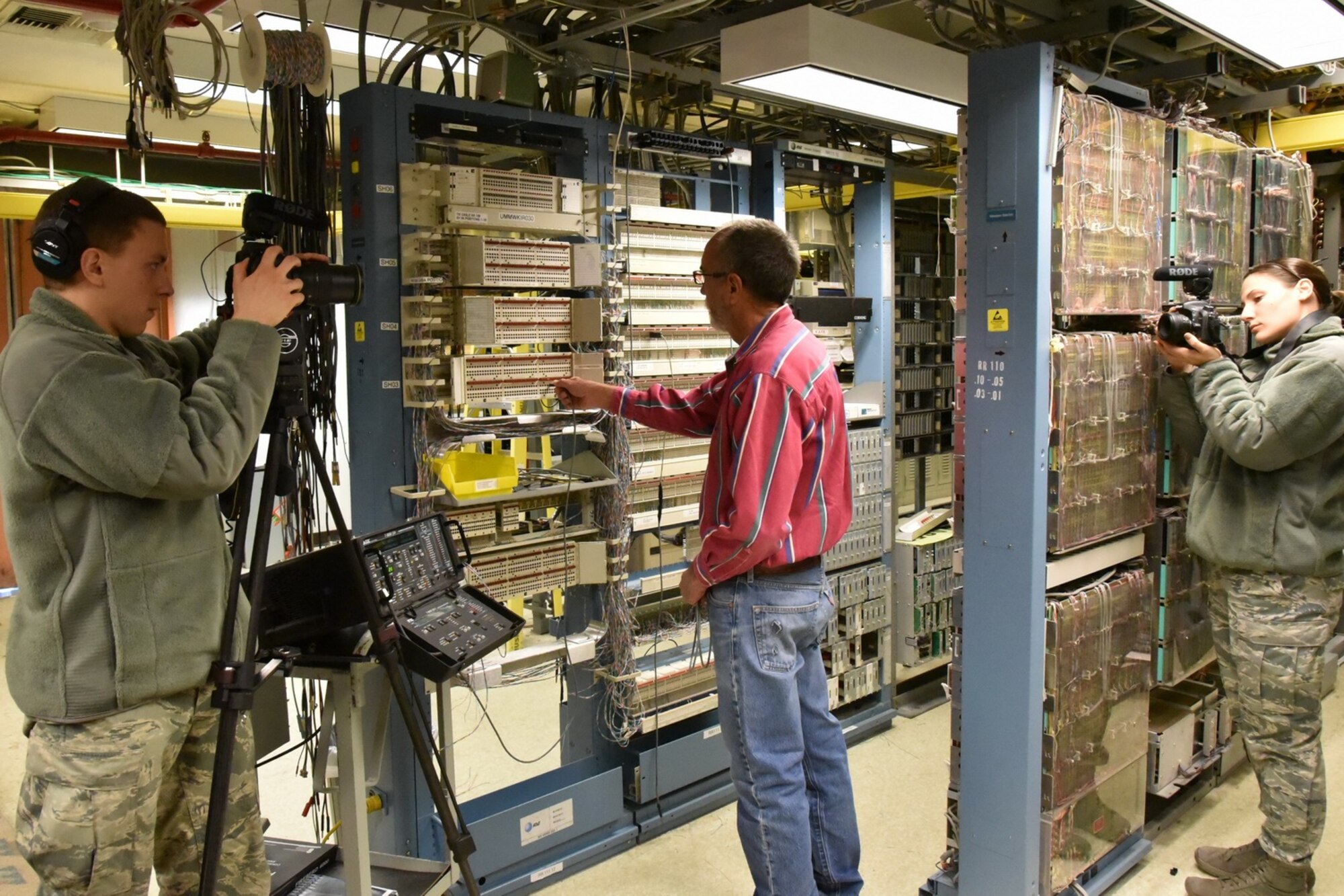 Airman 1st Class Gabriel Stuart, left, and Senior Airman Shellby Matullo, both from Barksdale Air Force Base, Louisiana, shoot video of a Kirtland employee at work. The videographers spent two weeks at Kirtland getting footage for a wing mission video. (Photo by Ken Moore)