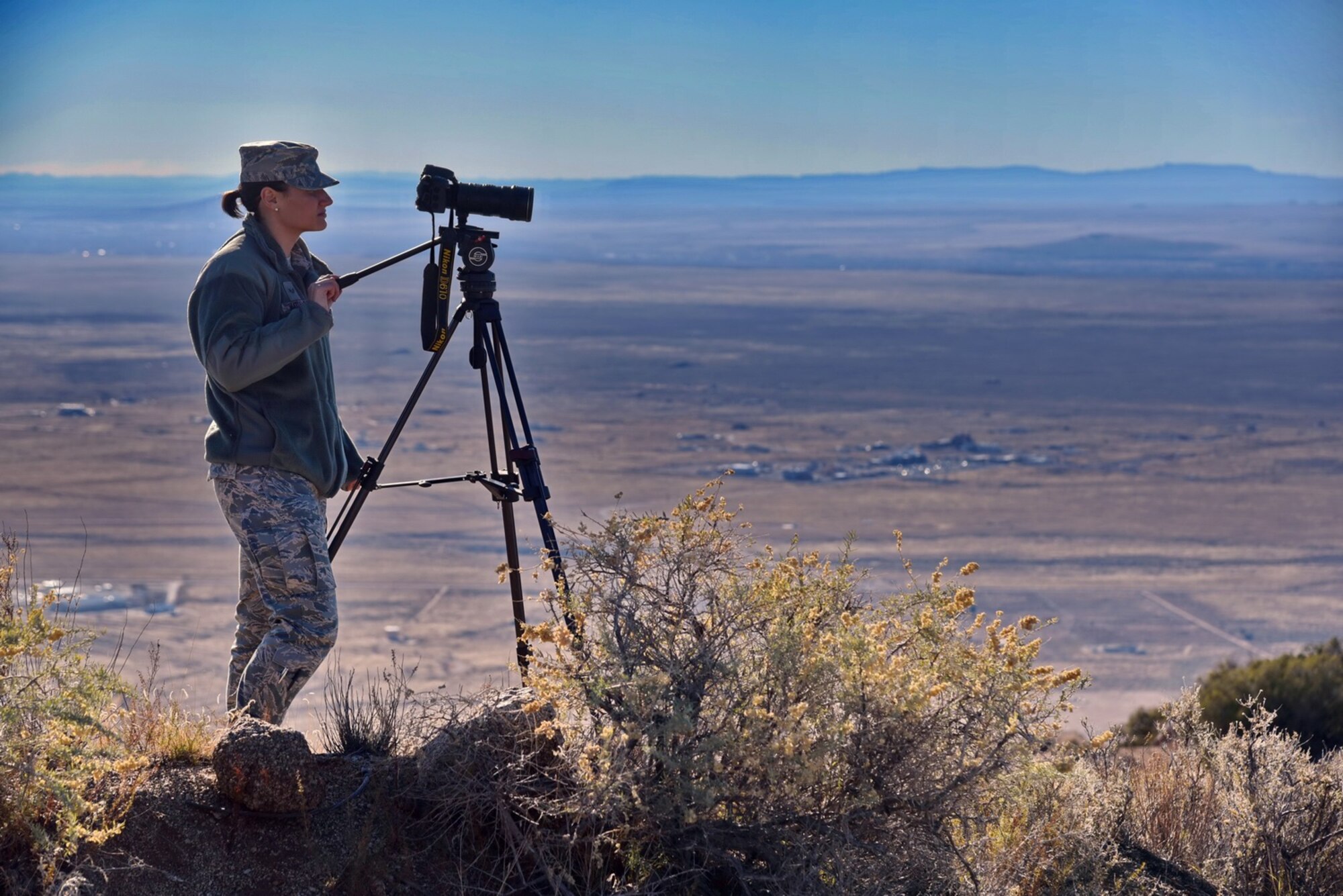 Senior Airman Shellby Matullo, from Barksdale Air Force Base, Louisiana, shoots video on a Kirtland hill overlooking the base. The videographers spent two weeks at Kirtland getting footage for a wing mission video. (Photo by Ken Moore)