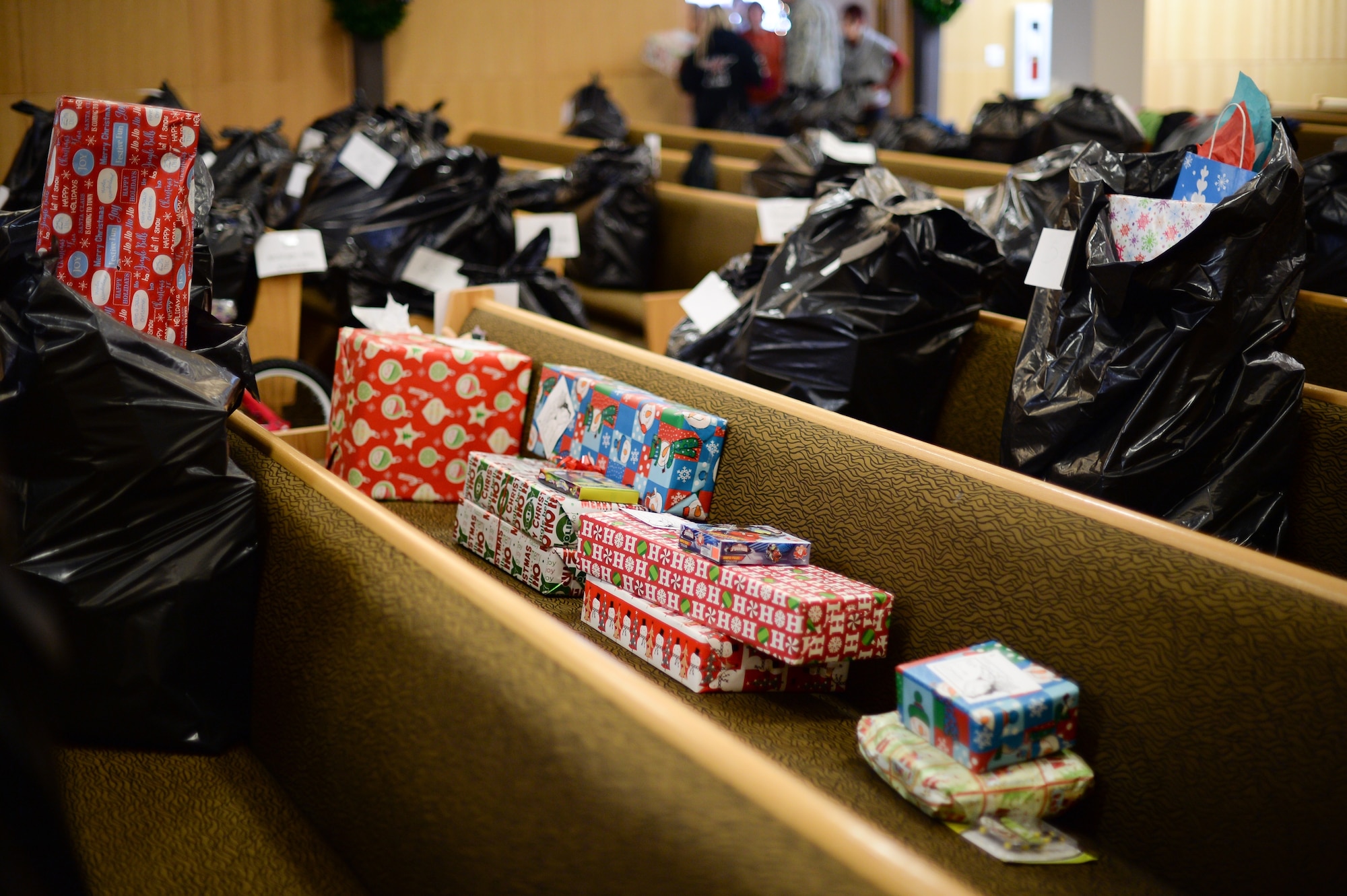 Several unsorted gifts sit on a pew in the base chapel Dec. 9 at Hill Air Force Base, Utah. After all the gifts were sorted and placed into plastic bags, Team Hill first sergeants picked up and distributed the presents to 300 military families on base. (U.S. Air Force photo by R. Nial Bradshaw)