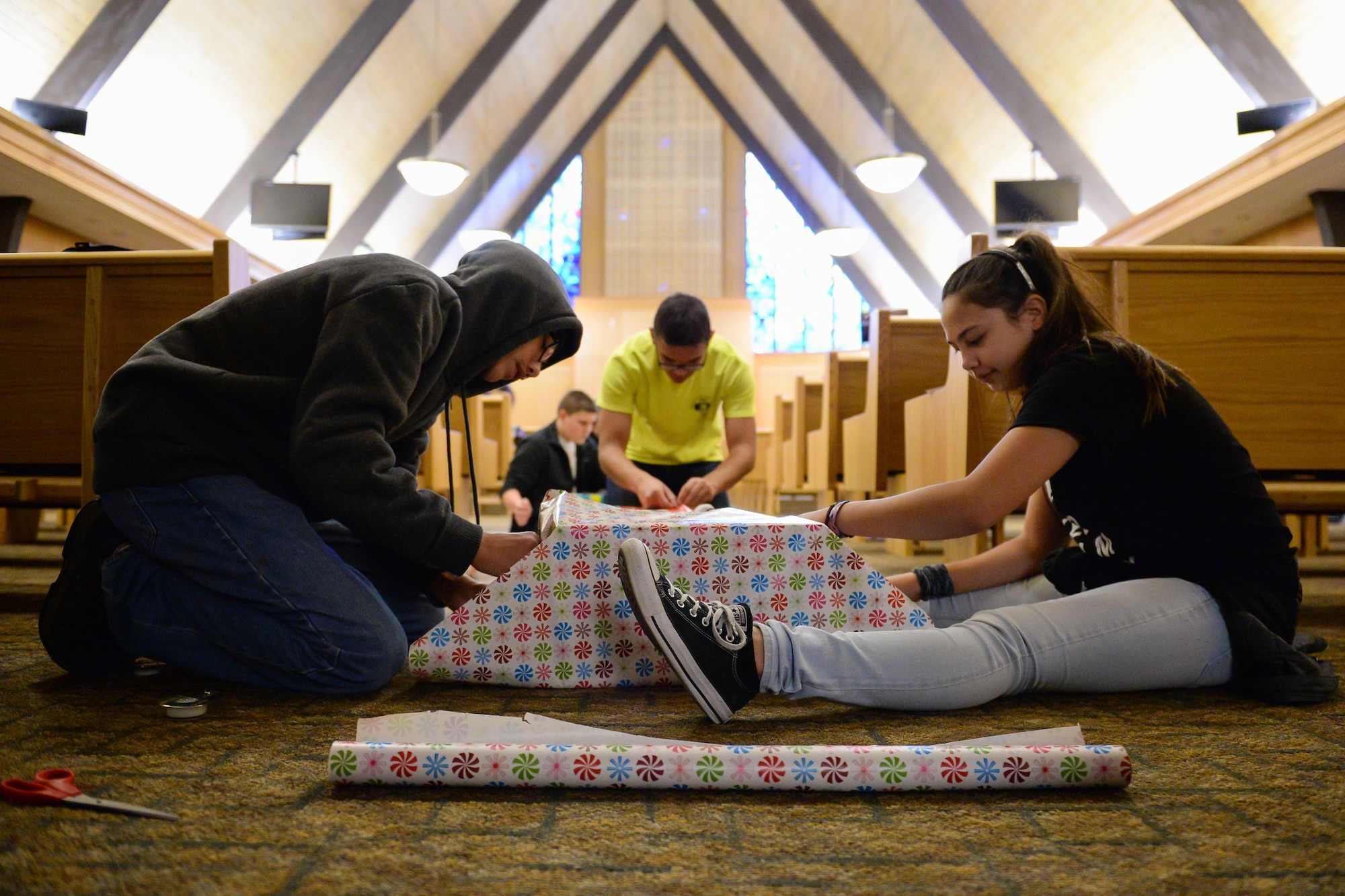 R.J. and Faith Magalong wrap Angel Tree donations Dec. 5 at the Hill Air Force Base’s chapel. Unwrapped donations were wrapped by volunteers from the Boy Scouts and the Hill AFB Youth Ministry. (U.S. Air Force photo by R. Nial Bradshaw)