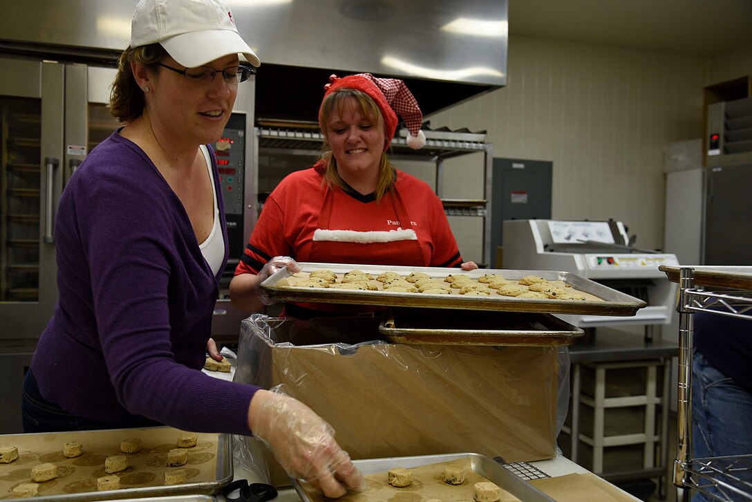 Karri Frizzell and Jessica McCollum, Cookie Caper committee members, portion cookie dough at Misawa Air Base, Japan, Dec. 7, 2015. The Misawa Commissary teamed up with volunteers to bake cookies for single and unaccompanied U.S. military and Japan Air Self-Defense Force service members on base. (U.S. Air Force photo by Airman 1st Class Jordyn Fetter/Released)