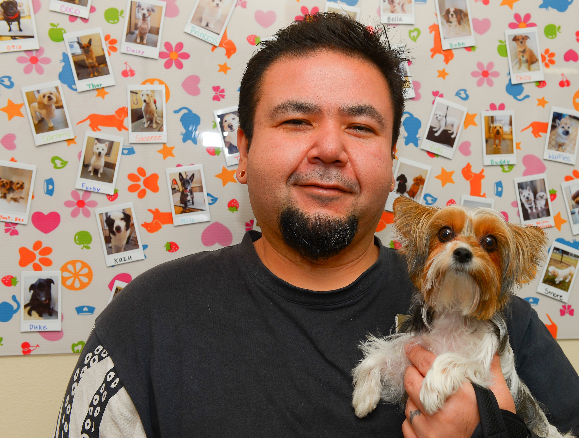 Buck Yabeno, Yokota Pet Care Center pet boarding manager, poses for a photo with a customer’s dog at Yokota Air Base, Japan, Dec. 9, 2015. Yabeno incorporates discipline training into the way he handles dogs boarded at the center, instilling basic behavior improvements. (U.S. Air Force photo by Airman 1st Class Elizabeth Baker/Released) 