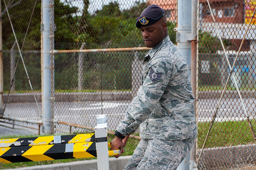 U.S. Air Force Tech. Sgt. Teddy Poole, 18th Security Forces Squadron police service NCO in charge, moves barriers in front of a gate during an exercise Dec. 3, 2015, at Kadena Air Base, Japan. Okinawa is susceptible to typhoons and flooding which can make other roads inaccessible. (U.S. Air Force photo by Airman 1st Class Corey M. Pettis) 