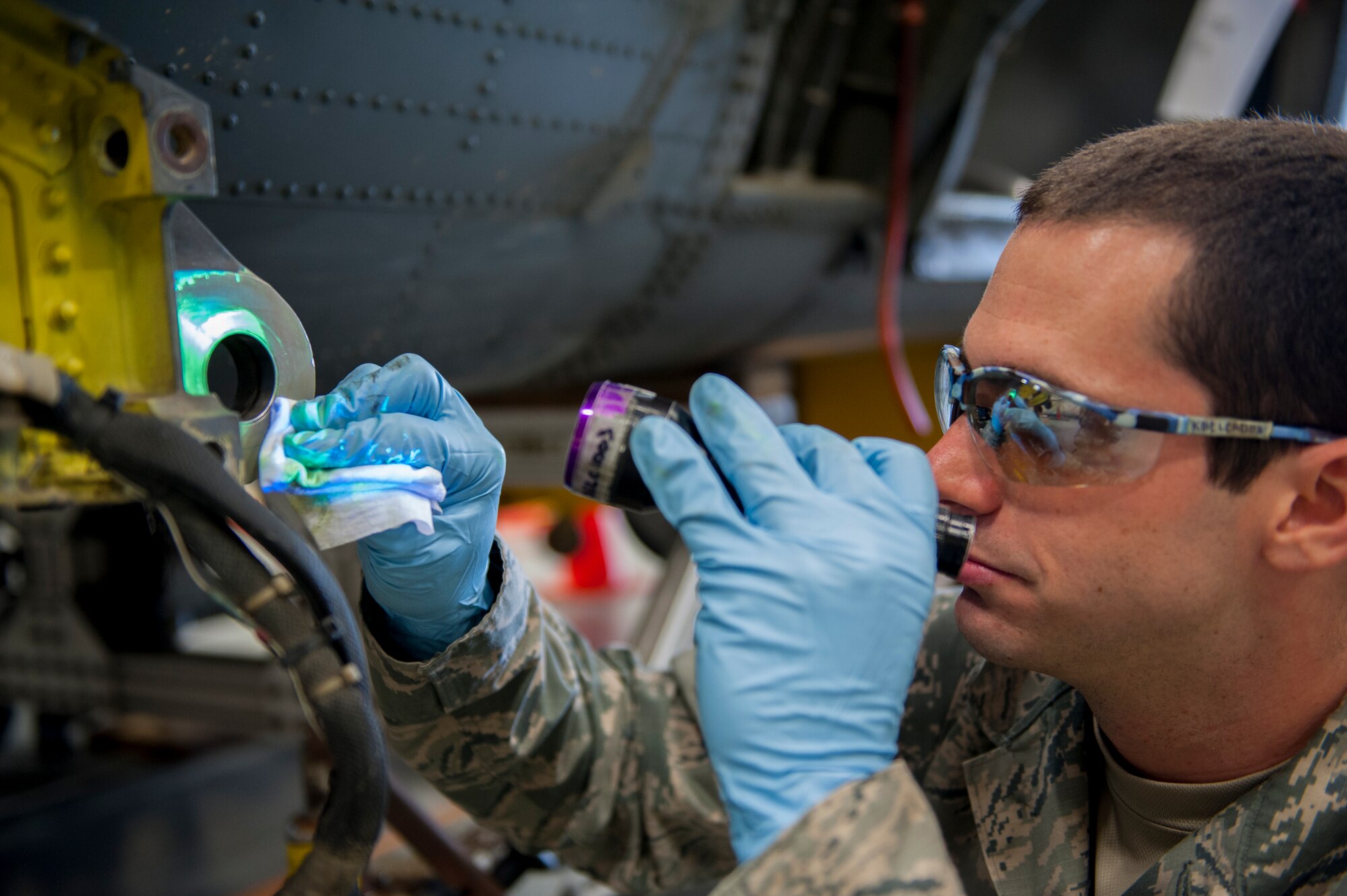 U.S. Air Force Senior Airman Kyle Black, 18th Equipment Maintenance Squadron non-destructive inspection technician, checks for cracks and chips that could lead to a structural failure during a phase inspection Dec. 10, 2015, at Kadena Air Base, Japan. The NDI team specializes in finding imperfections that would otherwise be almost undetectable. (U.S. Air Force photo by Airman Zackary A. Henry)