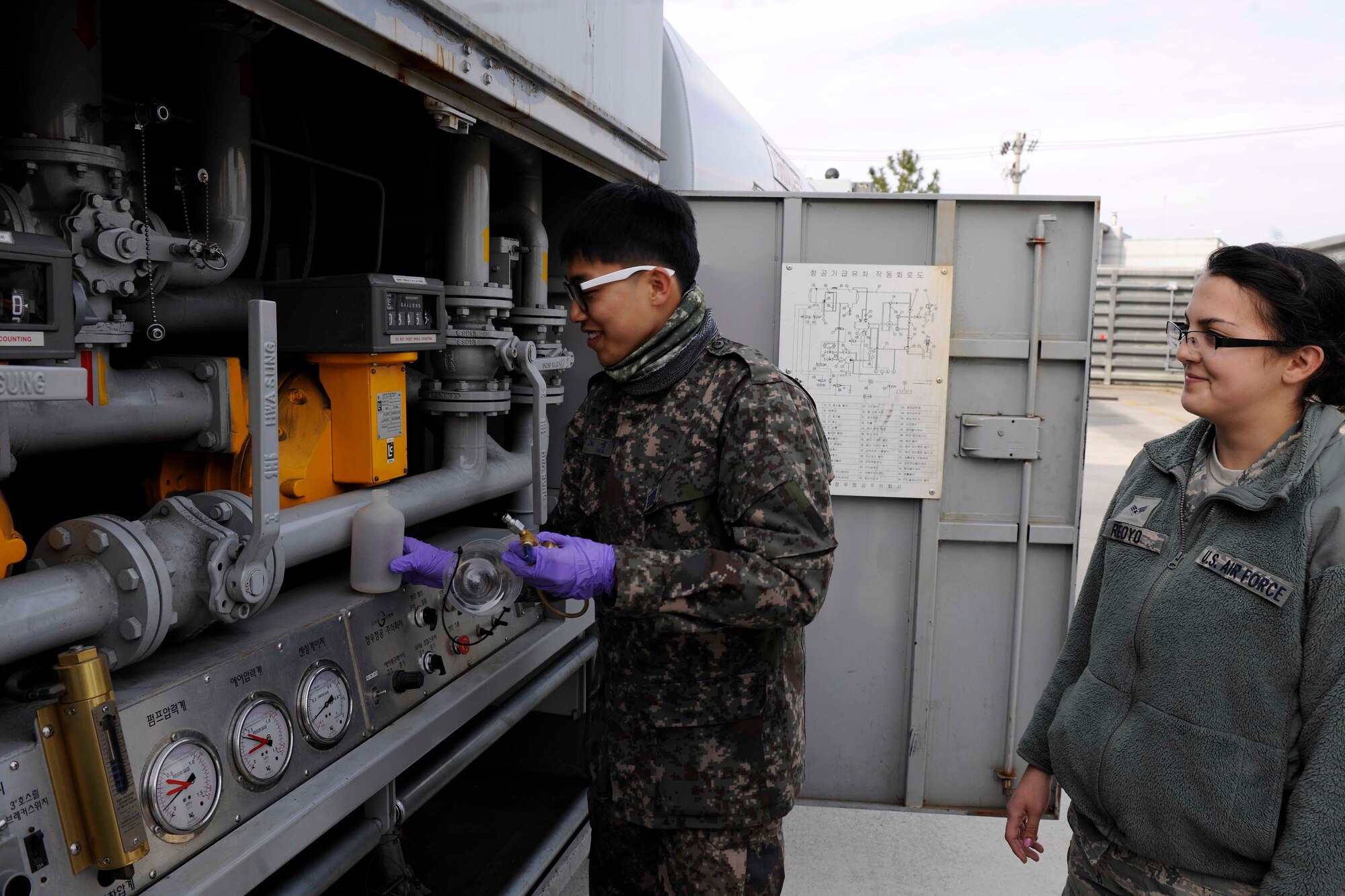 Republic of Korea Air Force Petroleum Oil Lubricants Airman demonstrates how they retrieve fuel from the ROK fuel trucks as part of the joint training at Kunsan Air Base, Republic of Korea on Dec. 8. This training is scheduled to take place every quarter to build partnership capacity with ROKAF counterparts.