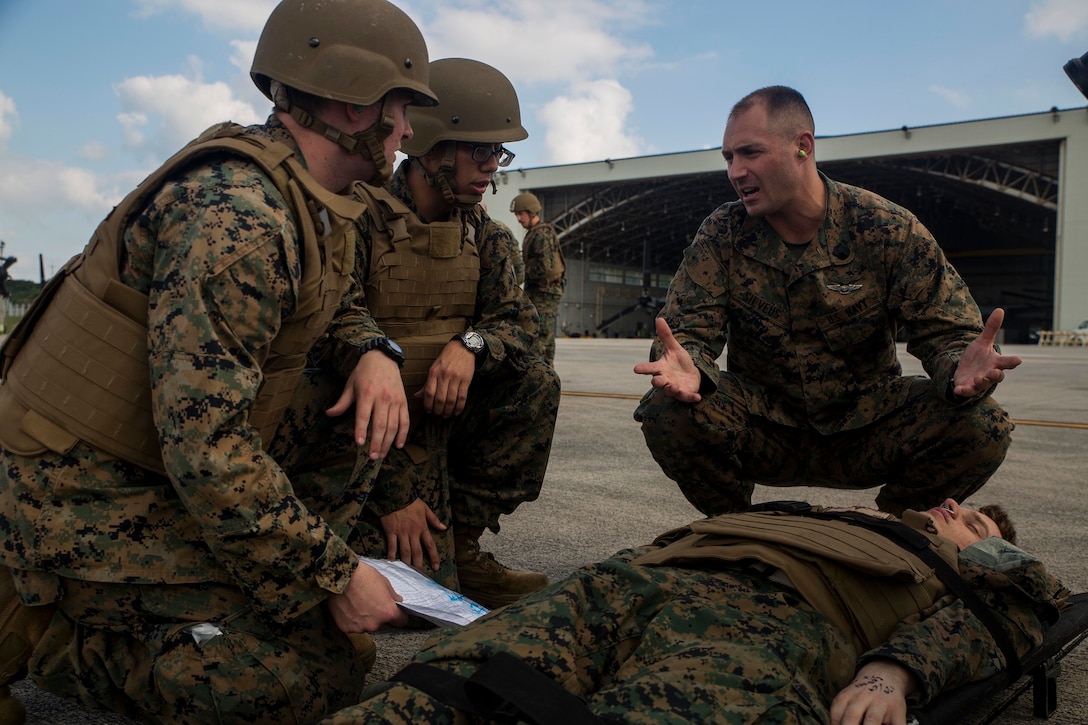 Petty Officer 1st Class Zachary Silveus, right, evaluates students after a casualty evacuation drill on Marine Corps Air Station Futenma, Dec. 8, 2015. The casevac course is two weeks long and gives the students a better understanding of what it means to be a corpsman. The corpsmen are with various units with III Marine Expeditionary Force. (U.S. Marine Corps photo by Cpl. Ryan C. Mains/ Released)