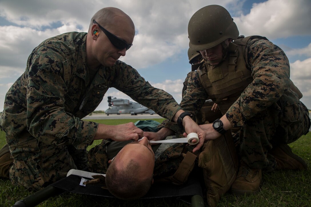Chief Johnathan Akers, left, helps Seaman Colin Mckeen, right, assess a simulated patient during a casualty evacuation drill on Marine Corps Air Station Futenma, Dec. 8, 2015. The casevac course is two weeks long and gives the students a better understanding of what it means to be a corpsman. The corpsmen are with various units with III Marine Expeditionary Force. (U.S. Marine Corps photo by Cpl. Ryan C. Mains/ Released)
