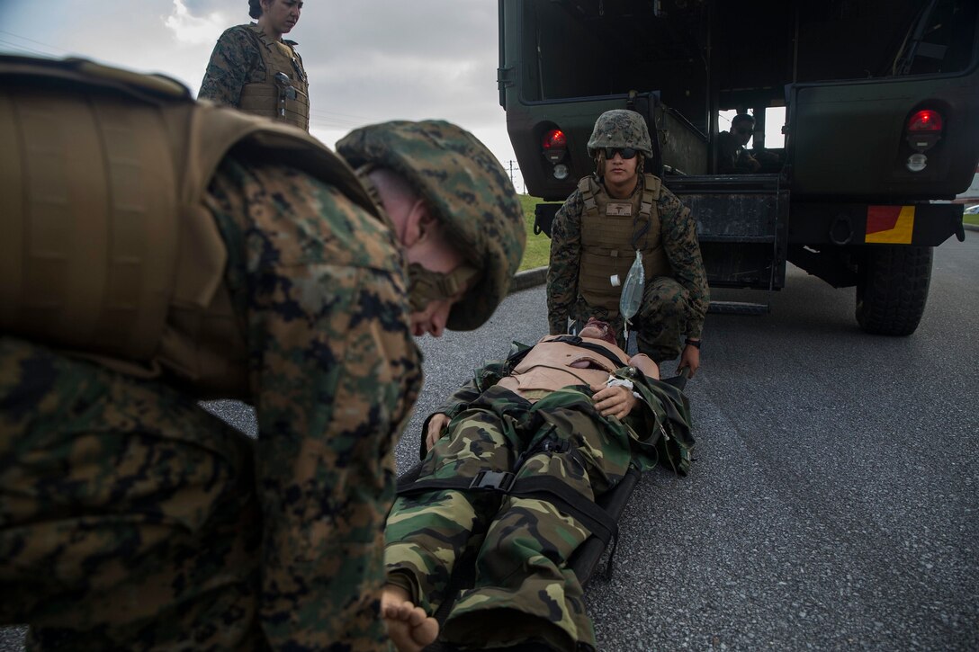 Hospital corpsmen lift a simulated casualty into M997 ambulance during a casualty evacuation drill on Marine Corps Air Station Futenma, Dec. 8, 2015. The casevac course is two weeks long and gives the students a better understanding of what it means to be a corpsman. The corpsmen are with various units with III Marine Expeditionary Force. (U.S. Marine Corps photo by Cpl. Ryan C. Mains/ Released)