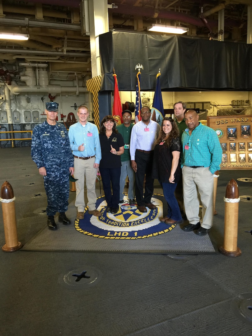 DLA Distribution Norfolk, Va., and OSHA staff stand on the quarterdeck of the USS Wasp (LHD 1) during their recent STAR recertification visit.
