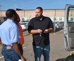 DLA Installation Support at Richmond employee Derrik Griner issues Defense Supply Center Richmond employees a government vehicle Oct. 13, 2015 and gives guidance on vehicle technology, safety and use.