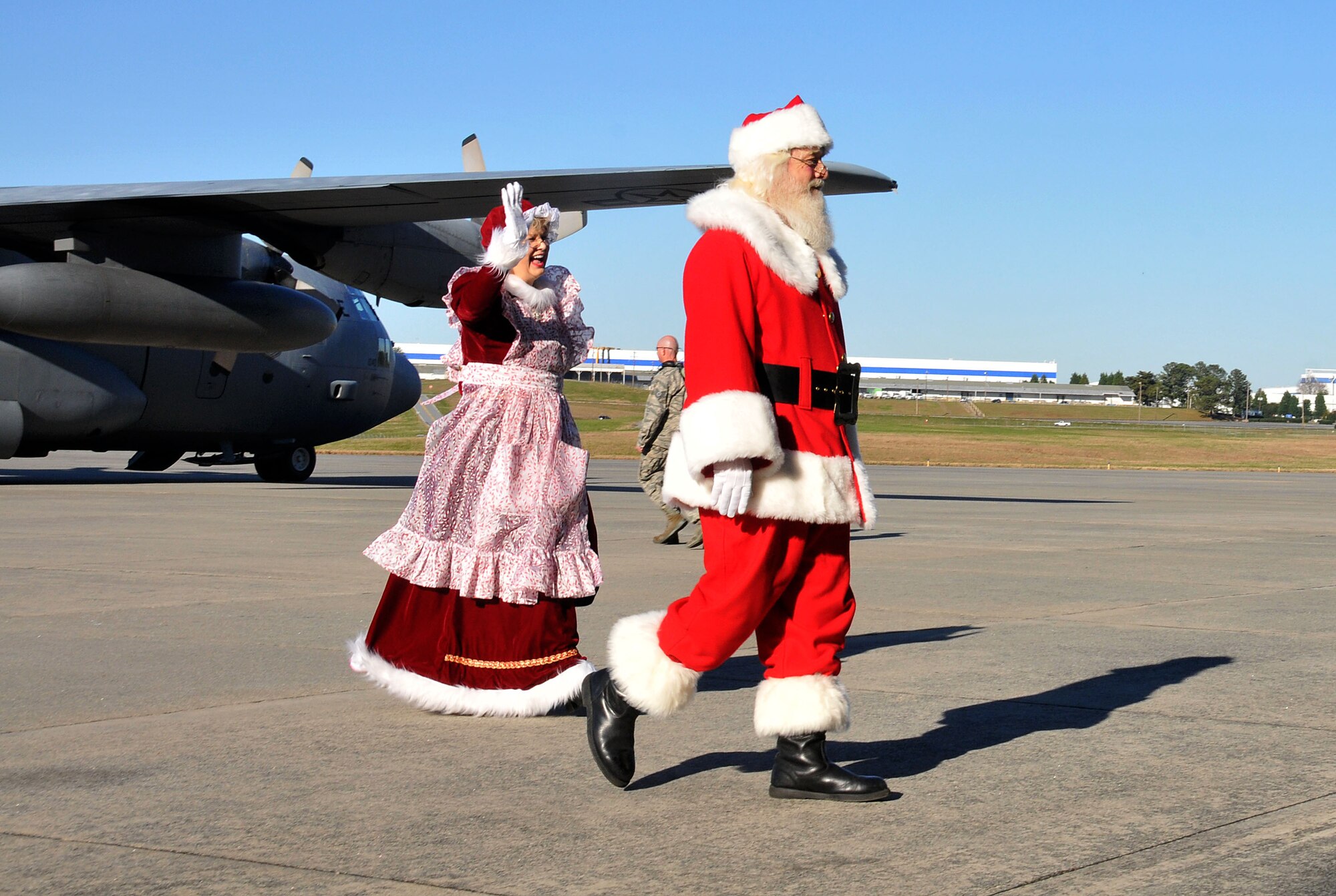 Mr. and Mrs. Santa Claus depart a C-130 Hercules and stroll toward Hangar 5 at Dobbins Air Reserve Base, Ga. on Dec. 5, 2015. The Clauses made a special trip to Dobbins to hear the Christmas wishes of families here. (U.S. Air Force photo/Senior Airman Andrew Park)