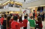 Children from the McNamara Headquarters Complex Child Development Center’s kindergarten class look on as Santa and his elves make their way down the stairs at the HQC Tree Lighting and Holiday Social Dec. 9. 