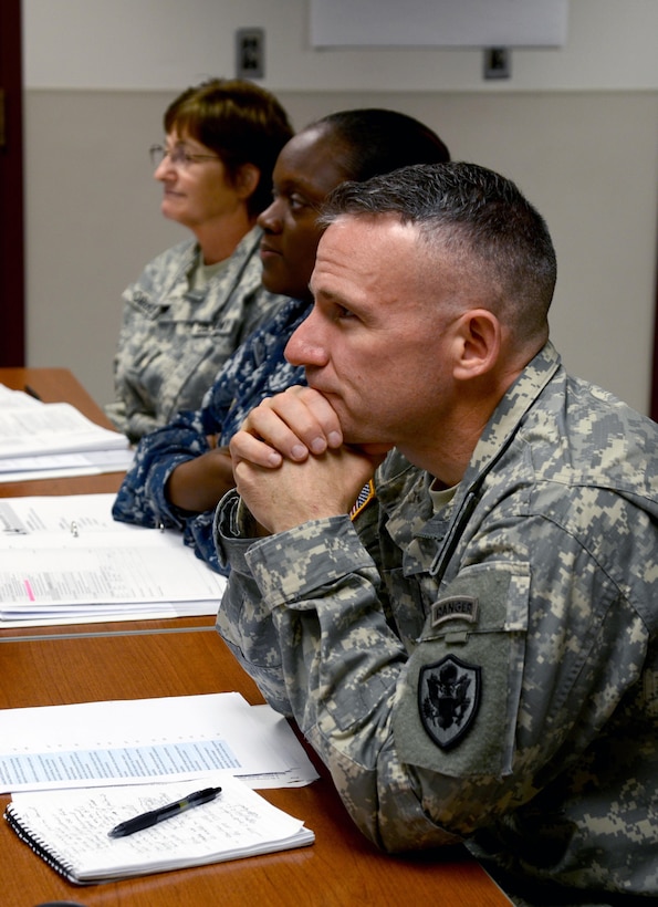 Col. Martin Downie, the commandant of the Defense Information School at Fort Meade, Md., listens to an instructor Nov. 9 during an Instructor Training Course class at the school. The Instructor Training Course trains prospective faculty members on effective teaching methods.