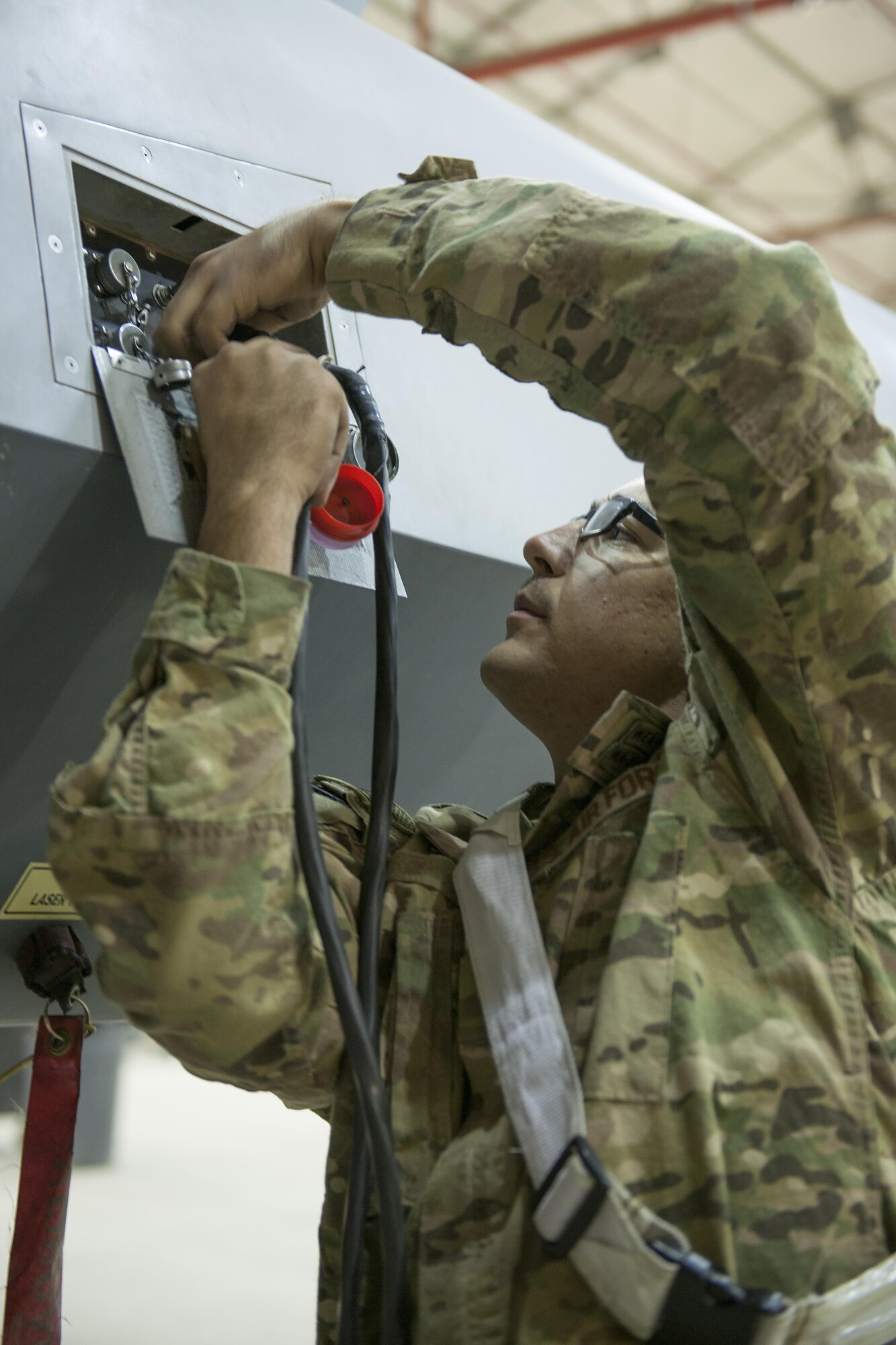 Senior Airman Curtis, 62nd Expeditionary Reconnaissance Squadron weapons load crew member, replaces a cap on an MQ-9 Reaper at Kandahar Airfield, Afghanistan, Dec. 6, 2015. The Reaper is an armed, multi-mission, medium-altitude, long-endurance remotely piloted aircraft that is employed primarily as an intelligence-collection asset and secondarily against dynamic execution targets. (U.S. Air Force photo by Tech. Sgt. Robert Cloys/Released)