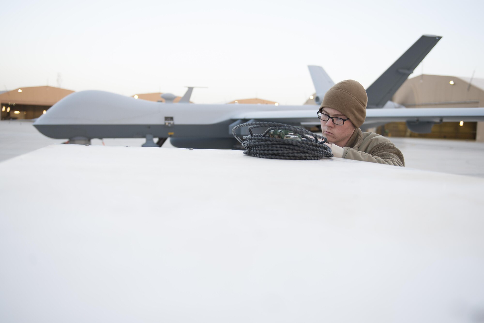 Airman 1st Class Devin, 62nd Expeditionary Reconnaissance Squadron aircraft specialist, puts away a power cable after preflight checks on an MQ-9 Reaper at Kandahar Airfield, Afghanistan, Dec. 6, 2015. The Reaper is an armed, multi-mission, medium-altitude, long-endurance remotely piloted aircraft that is employed primarily as an intelligence-collection asset and secondarily against dynamic execution targets. (U.S. Air Force photo by Tech. Sgt. Robert Cloys/Released)