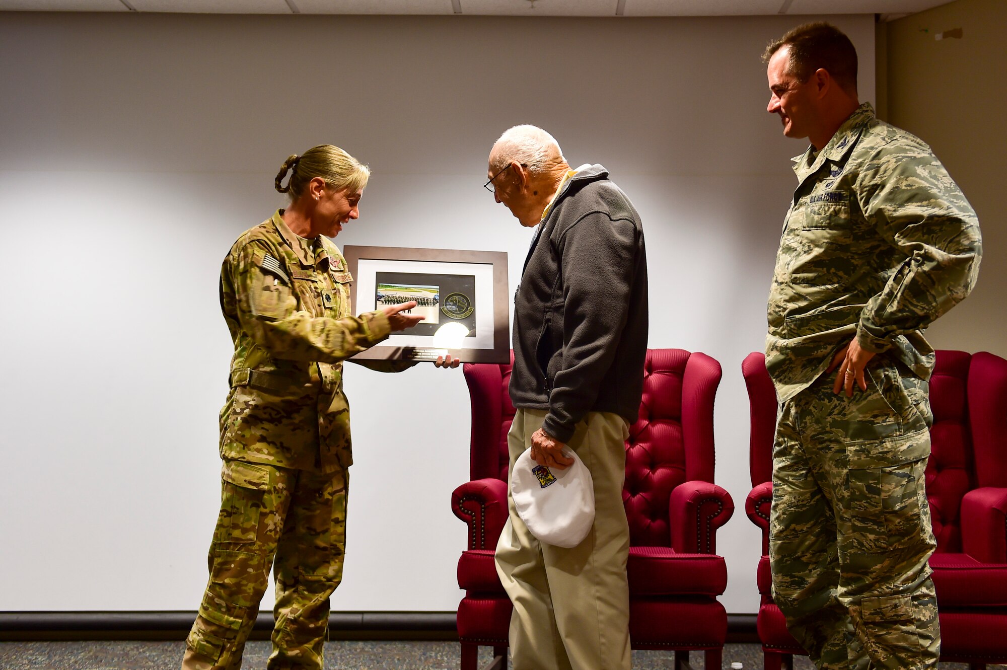 Lt. Col. Allison Black, commander of the 319th Special Operations Squadron, presents retired Lt. Col. Richard E. Cole, a Doolittle Raider, with a gift after a Q&A session at the 319th Special Operations Squadron, Hurlburt Field, Fla., Dec. 9, 2015. As a pilot and engineering officer for the transport section of the 1st Air Commando Group, Cole helped stand up the 319th SOS, known then as the “question mark squadron.” (U.S. Air Force photo by Senior Airman Jeff Parkinson)