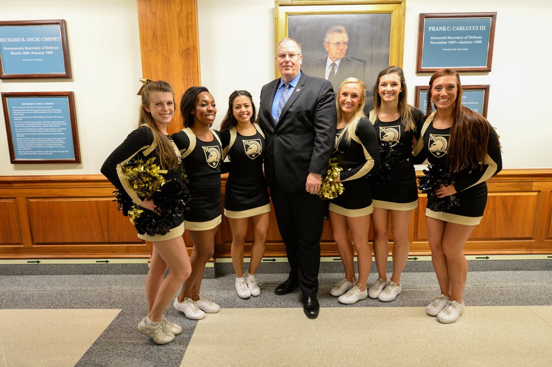 Deputy Defense Secretary Bob Work poses for a photograph with the Army's cheerleading squad during a pep rally at the Pentagon, Dec. 11, 2015, before the upcoming Army-Navy football game. DoD photo by Army Sgt. 1st Class Clydell Kinchen