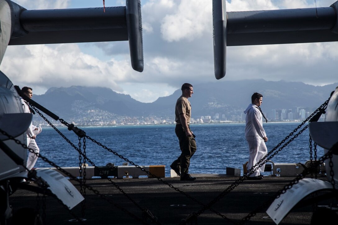 PEARL HARBOR, Hawaii (Dec. 3, 2015) U.S. Marines and Sailors move to their locations to man the rails on the flight deck of the USS Essex (LHD-2) while pulling into port.  Hawaii is the 15th Marine Expeditionary Unit’s last port call before heading home after their WESTPAC 15 deployment. (U.S. Marine Corps photo by Sgt. Elize McKelvey/Released)