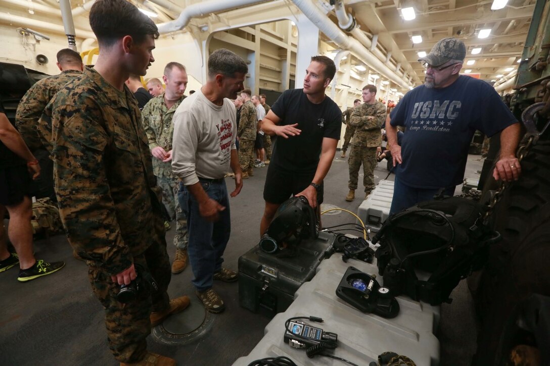 PACIFIC OCEAN (Dec. 8, 2015) U.S. Marines with the 15th Marine Expeditionary Unit’s Maritime Raid Force display the equipment they use on a day-to-day basis with family members and allow them to get hands on experience in the well deck aboard the USS Anchorage (LPD 23). The 15th MEU is coming to the end of deployment and hosting a Tiger Cruise for family members to showcase life aboard the Anchorage. (U.S. Marine Corps photo by Sgt. Steve H. Lopez/Released)