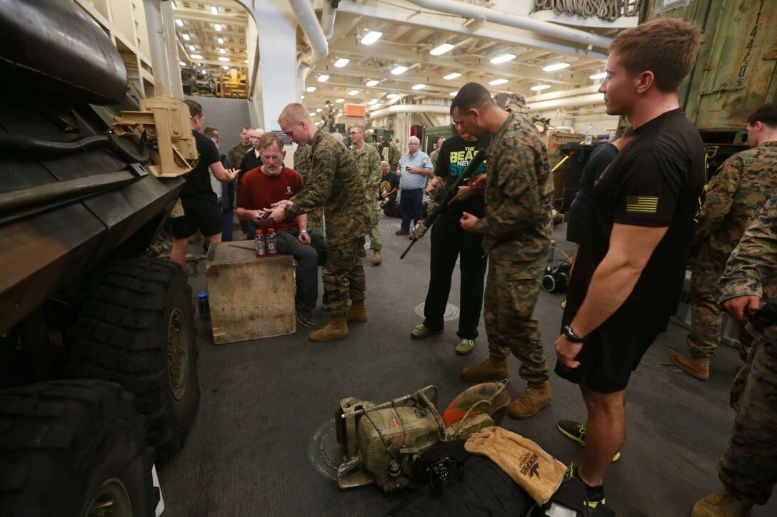 PACIFIC OCEAN (Dec. 8, 2015) U.S. Marines with the 15th Marine Expeditionary Unit’s Maritime Raid Force display the equipment they use on a day-to-day basis to family members and allow them to get hands on experience in the well deck aboard the USS Anchorage (LPD 23). The 15th MEU is coming to the end of deployment and hosting a Tiger Cruise for family members to showcase life aboard the Anchorage. (U.S. Marine Corps photo by Sgt. Steve H. Lopez/Released)